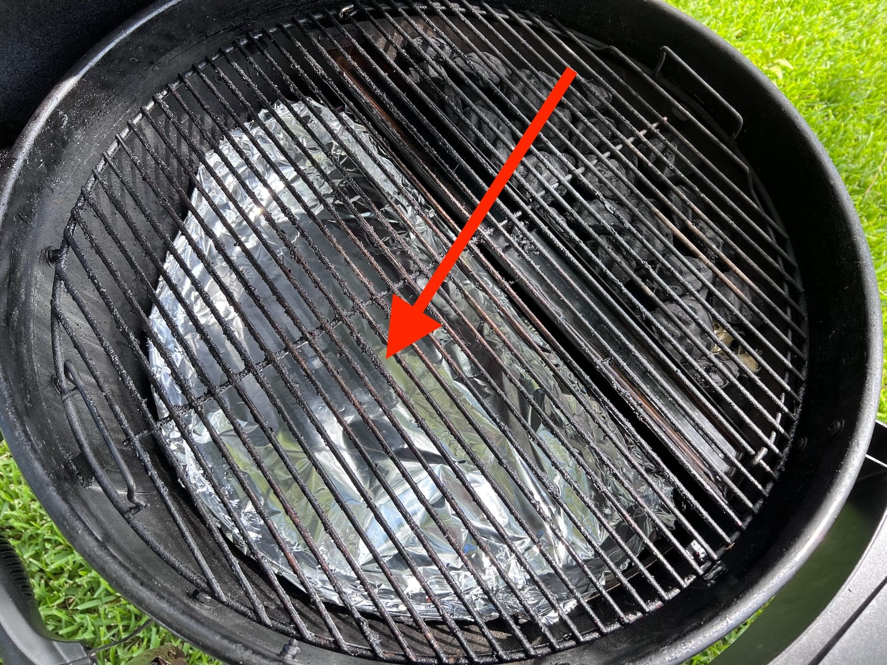 Drip N Griddle pan sitting below cooking surface to catch drippings while cooking.