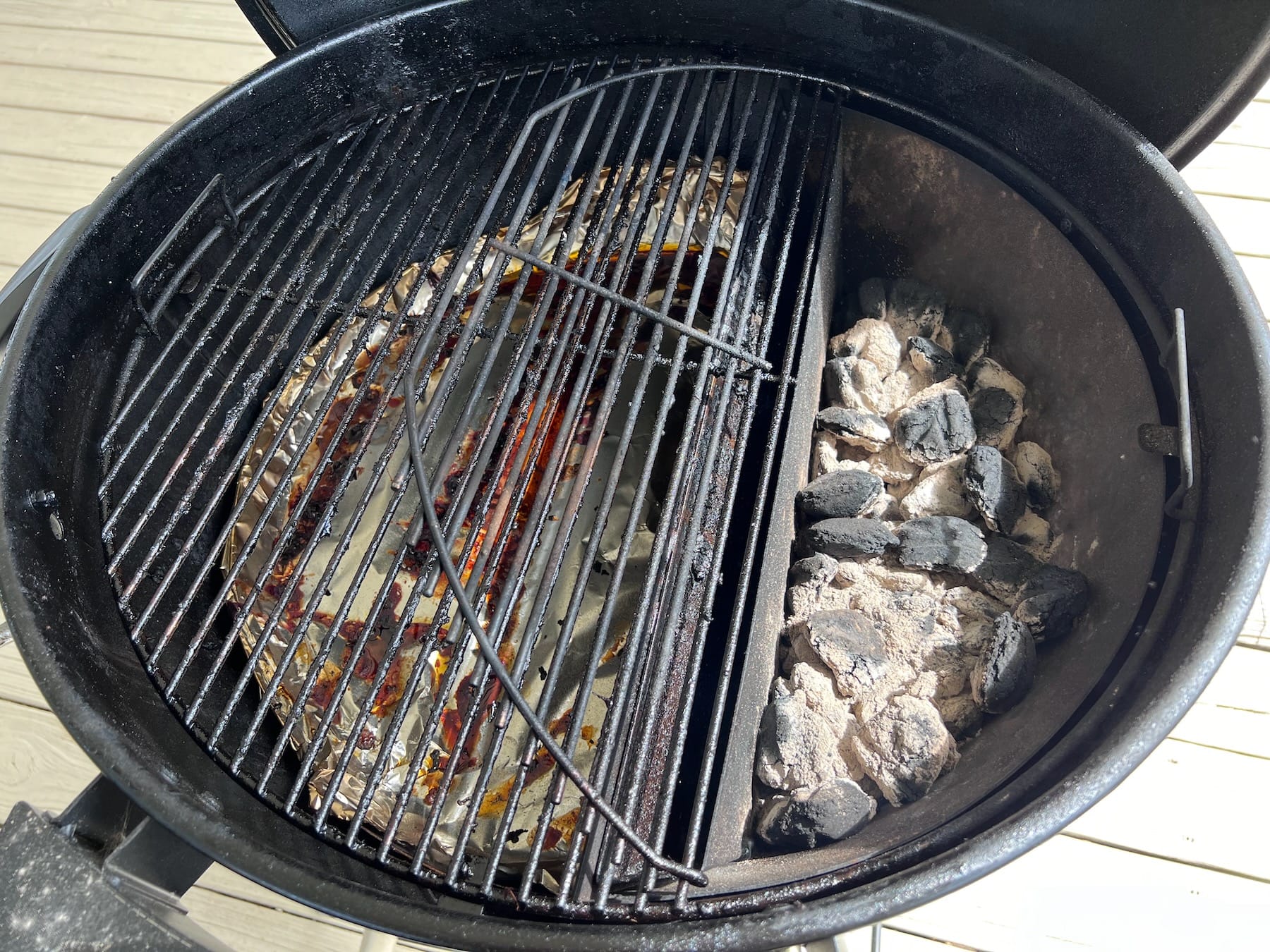 Hinged grate over charcoal allows for easy refueling and charcoal management.